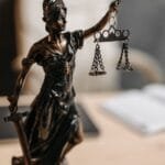 Bronze Lady Justice statue with scales and sword, symbolizing fairness and law.
